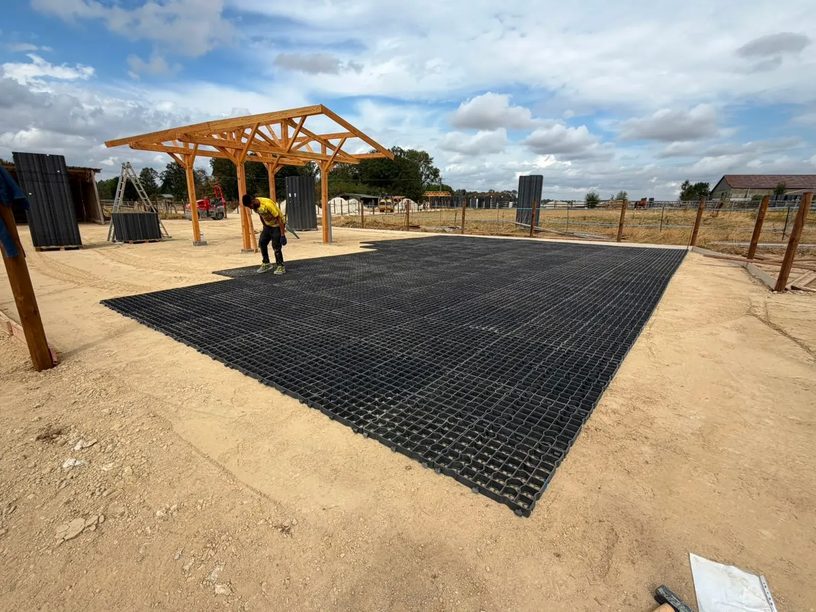 Grande surface de dalles de stabilisation posée devant l’abri en charpente bois